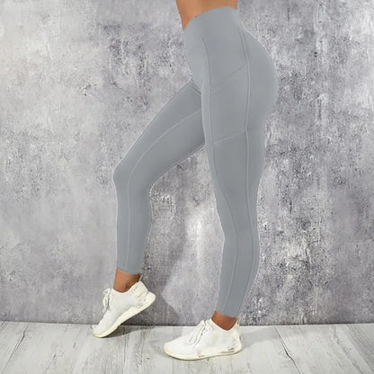 Person wearing gray leggings and white sneakers against a concrete wall.