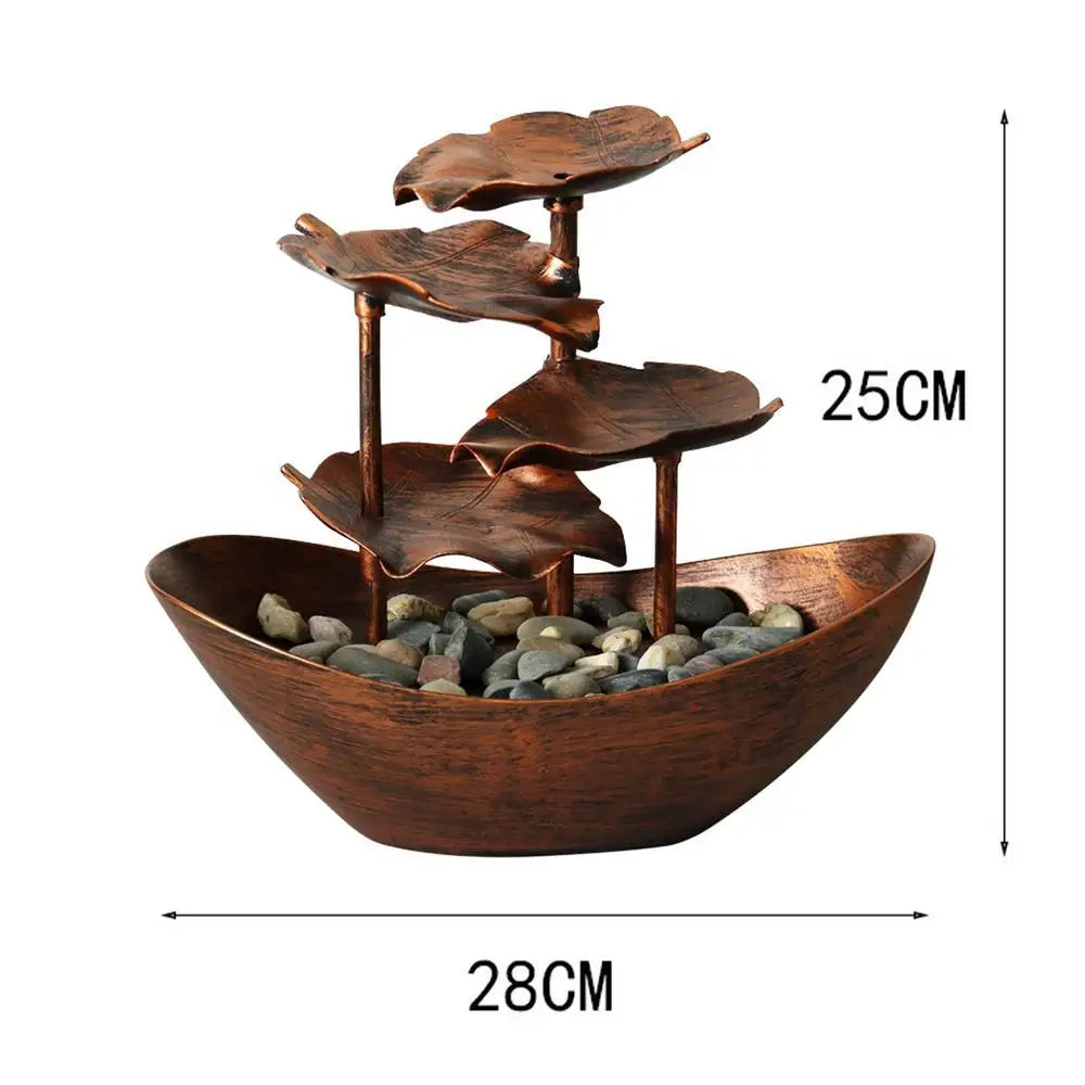 Decorative copper water fountain with leaf designs and pebbles, shown with dimensions on a white background.
