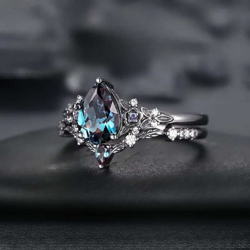 Elegant ring with a pear-shaped gemstone on a dark background