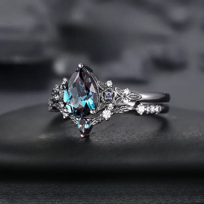 Elegant ring with a pear-shaped gemstone on a dark background