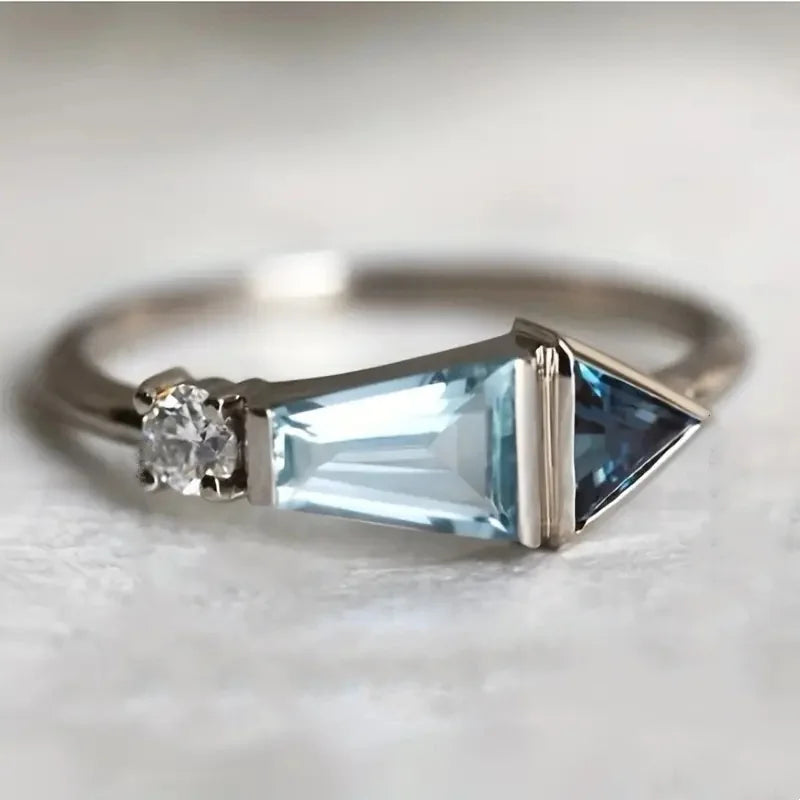 Silver ring with blue gemstones on a light background