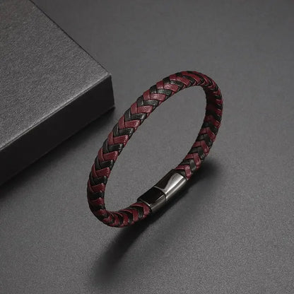 Braided red and black leather bracelet with a silver clasp on a gray background
