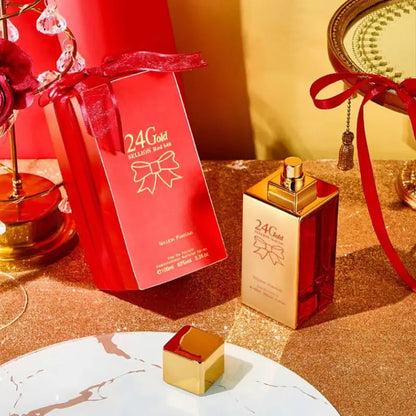 Perfume bottle and packaging with '24K Gold' branding on a decorative surface.