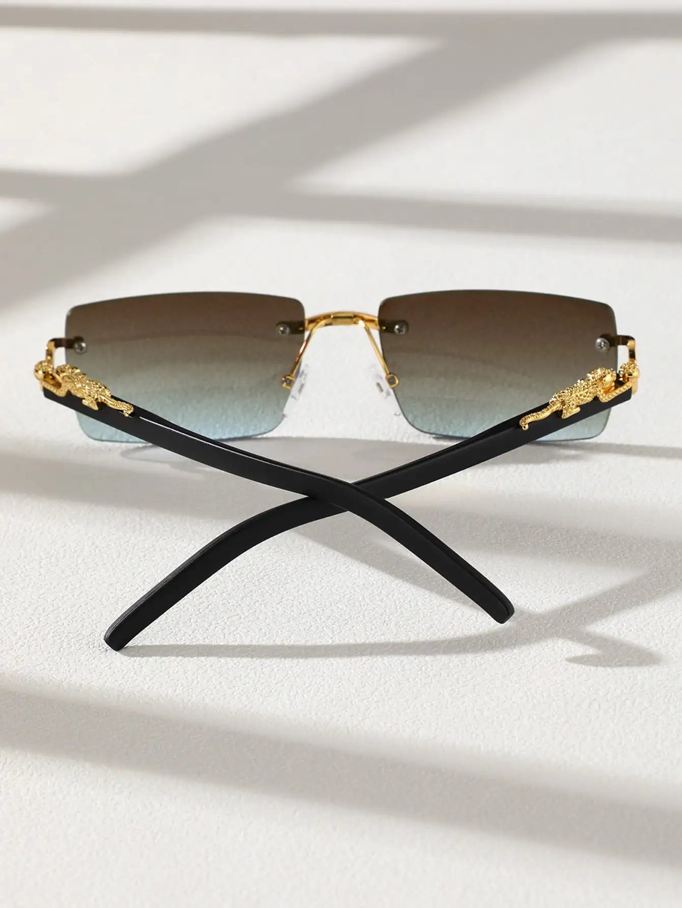 Sunglasses with gold frames and black arms on a white background