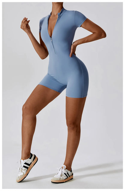Person wearing a blue bodysuit with matching shorts on a light gray background