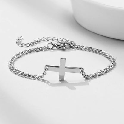Silver chain bracelet with a cross pendant on a white background
