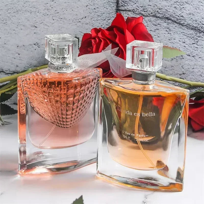 Two perfume bottles with red roses on a textured surface