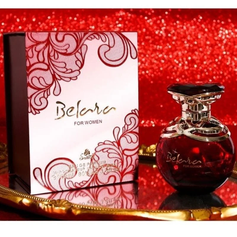 Belara perfume bottle and packaging on a red glittery background