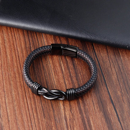 Black braided leather bracelet on a wooden surface