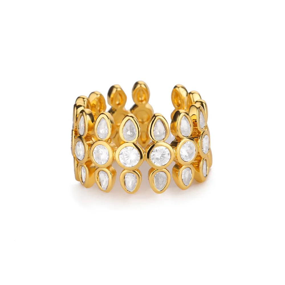 Gold ring with teardrop-shaped gemstones on a white background