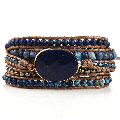 Multistrand bracelet with blue beads and a large blue stone on a white background