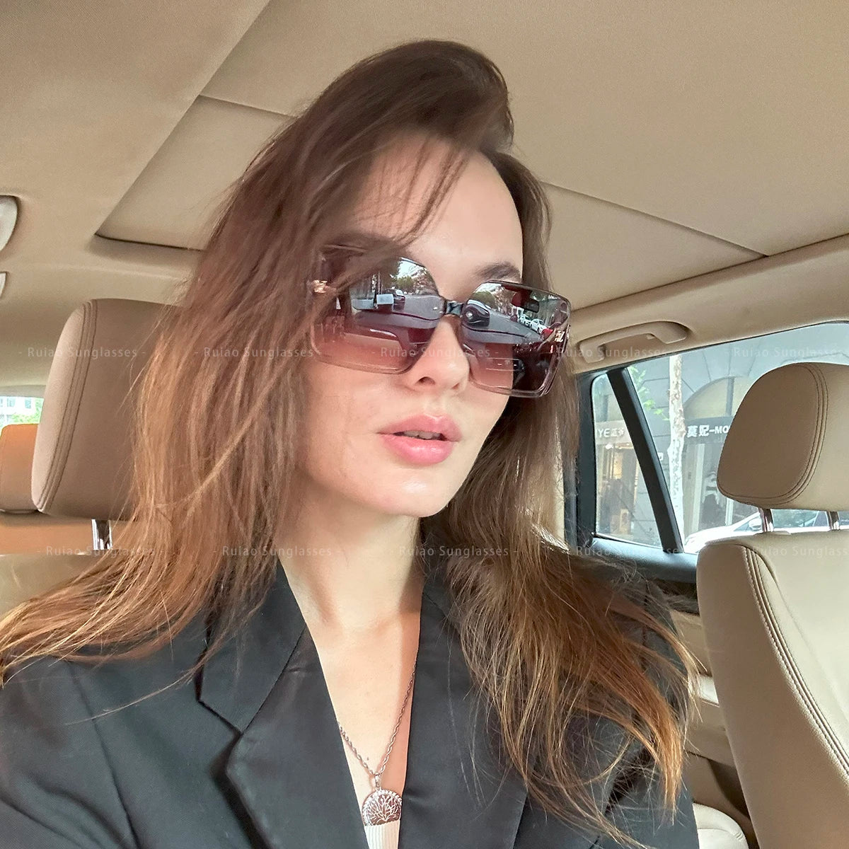 Woman wearing sunglasses sitting inside a car