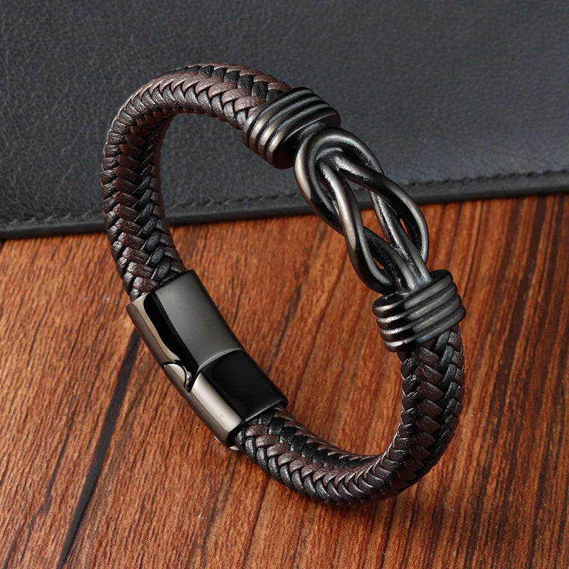 Brown braided leather bracelet with metal clasp on a wooden surface