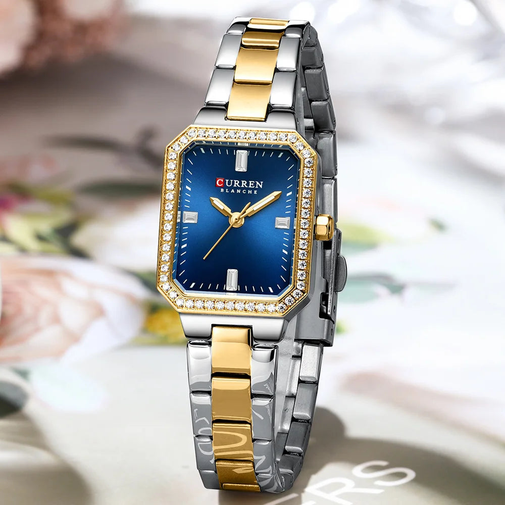 Two-tone silver and gold watch with a blue face on a blurred floral background