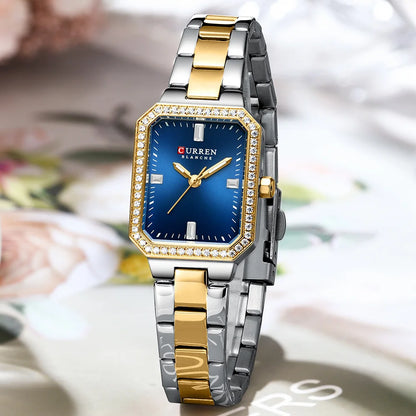 Two-tone silver and gold watch with a blue face on a blurred floral background