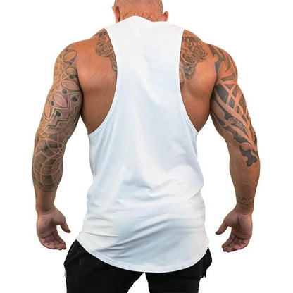 Man wearing a white tank top with visible tattoos on arms and back.