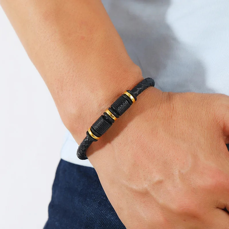 Black beaded bracelet with gold accents on a wrist against a neutral background