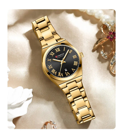 Gold wristwatch with black dial on a soft beige background