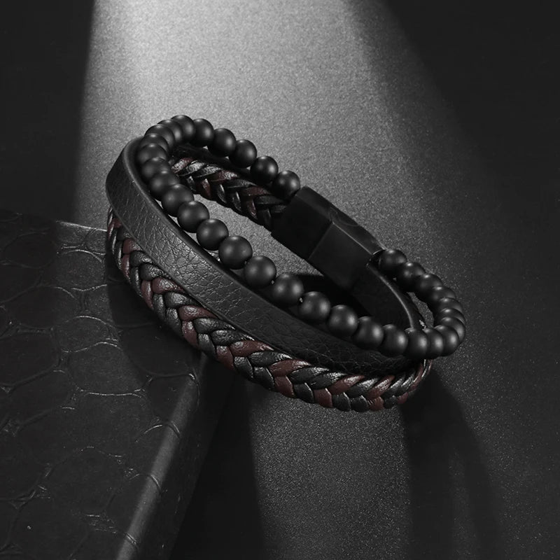 Black beaded bracelet with braided design on a dark textured surface