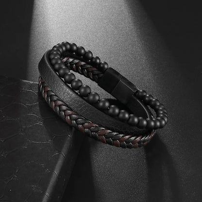 Black beaded bracelet with braided design on a dark textured surface