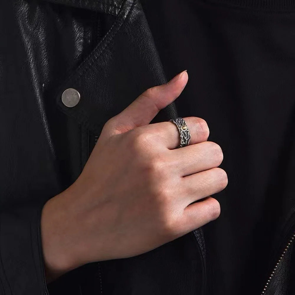 Hand wearing a silver ring with a dark background