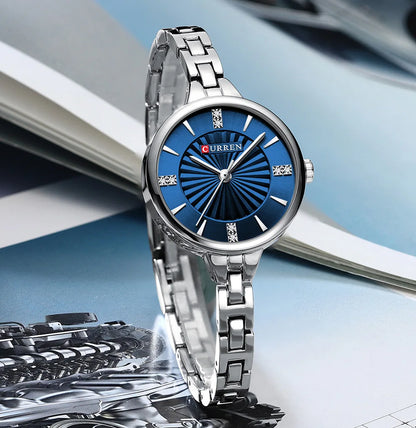 Silver watch with blue dial on a blurred background