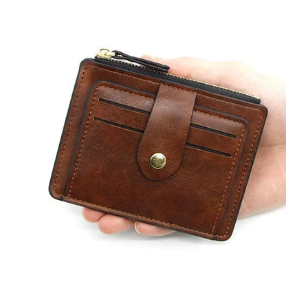 Brown leather wallet with a gold button held by a hand on a white background