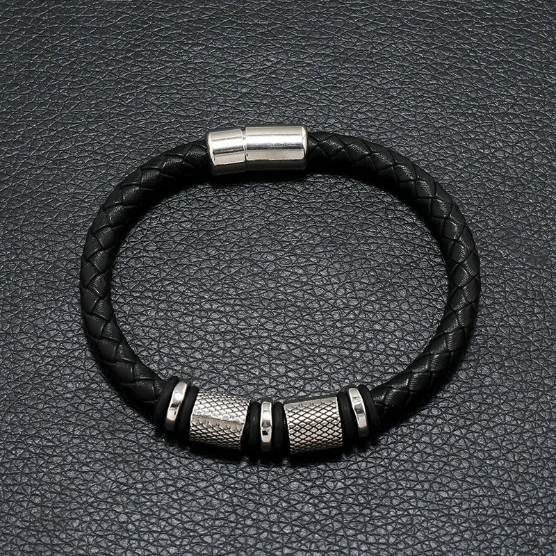 Black braided leather bracelet with silver metal accents on a black textured background