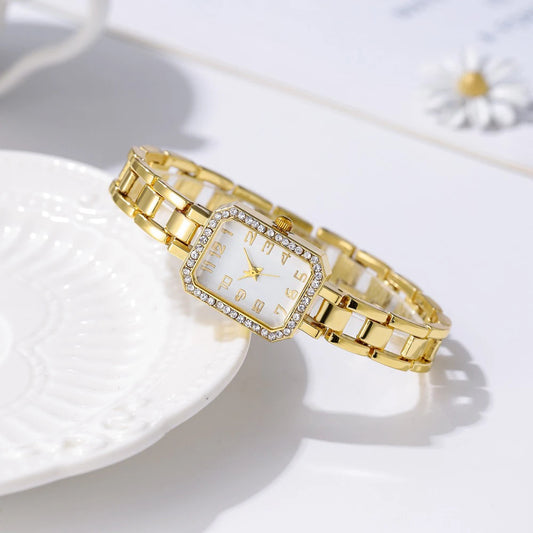 Gold wristwatch with a square face on a white surface