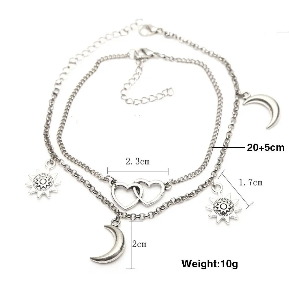 Silver anklet with charms and measurements on a white background