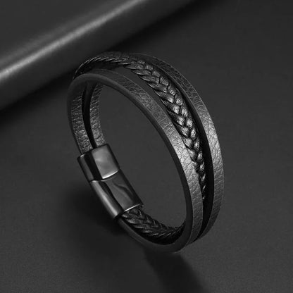 Black braided leather bracelet with a metal clasp on a dark background