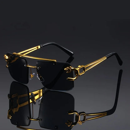 Gold-framed sunglasses with black lenses on a reflective surface.
