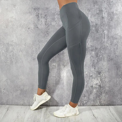 Person wearing gray leggings and white sneakers against a concrete wall.