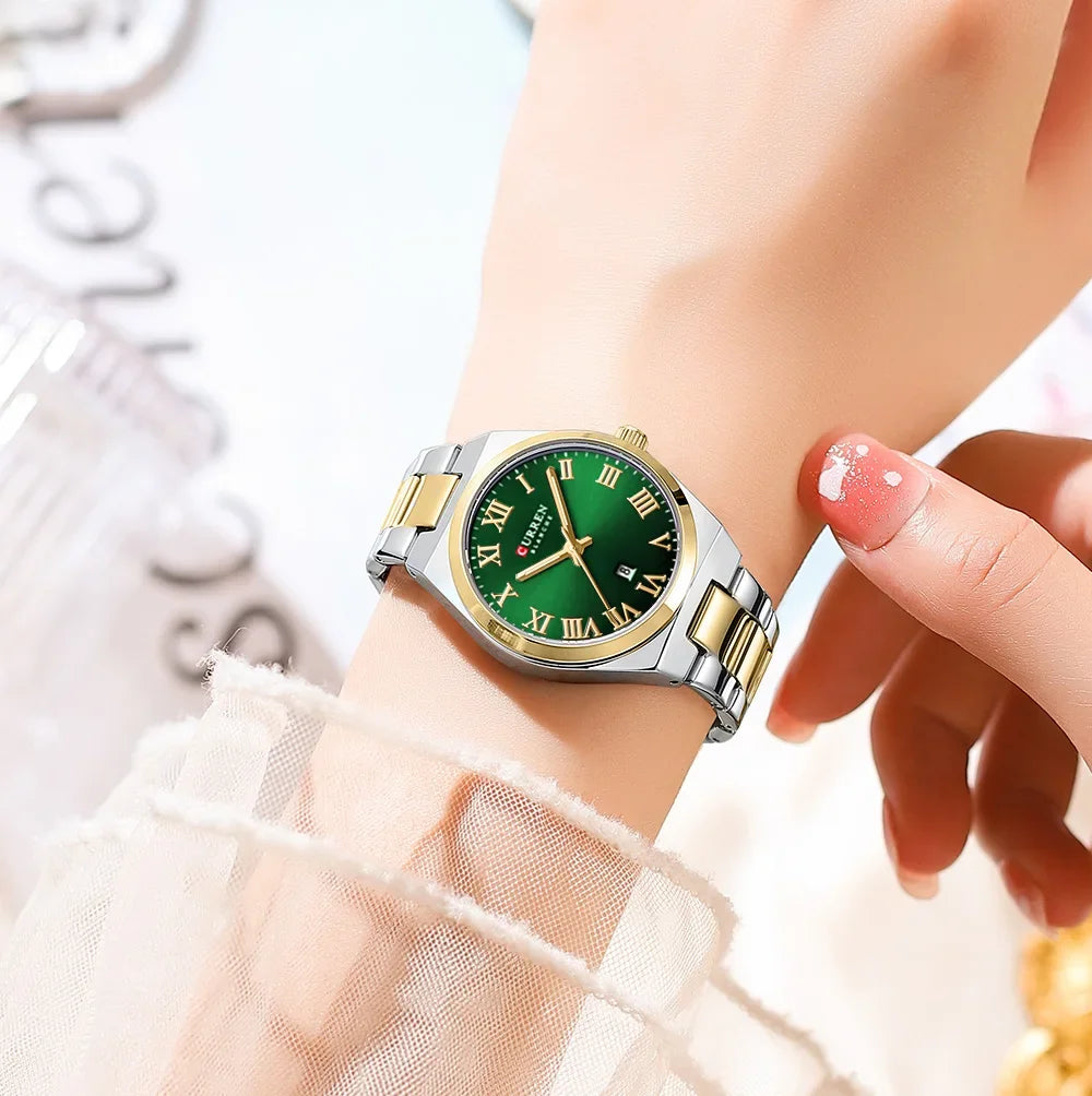 Gold and green watch on a wrist with a blurred background