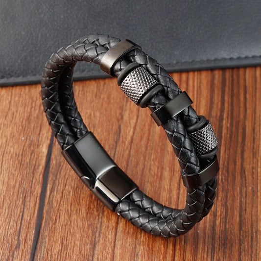Black braided leather bracelet with metal clasp on a wooden surface