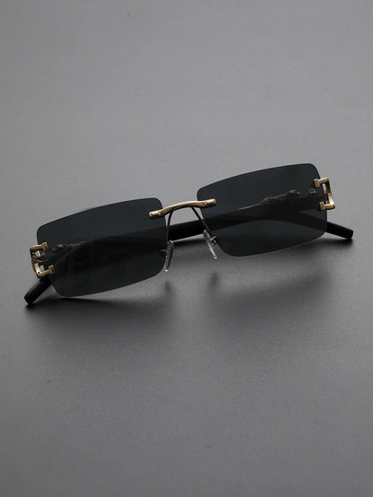 Black sunglasses with gold accents on a gray background