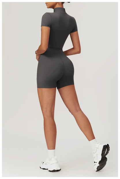 Person wearing a gray bodysuit on a light gray background