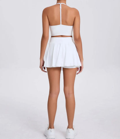 Person wearing a white outfit with a skirt on a plain background