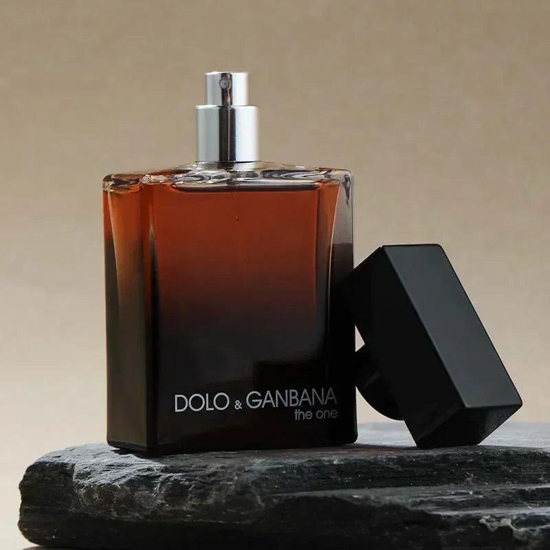 Perfume bottle with black cap on a stone surface against a beige background