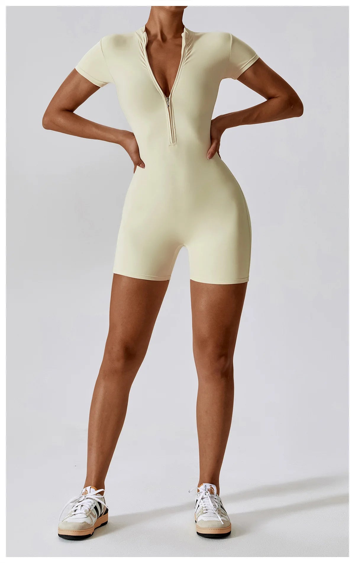 Person wearing a beige bodysuit against a plain background