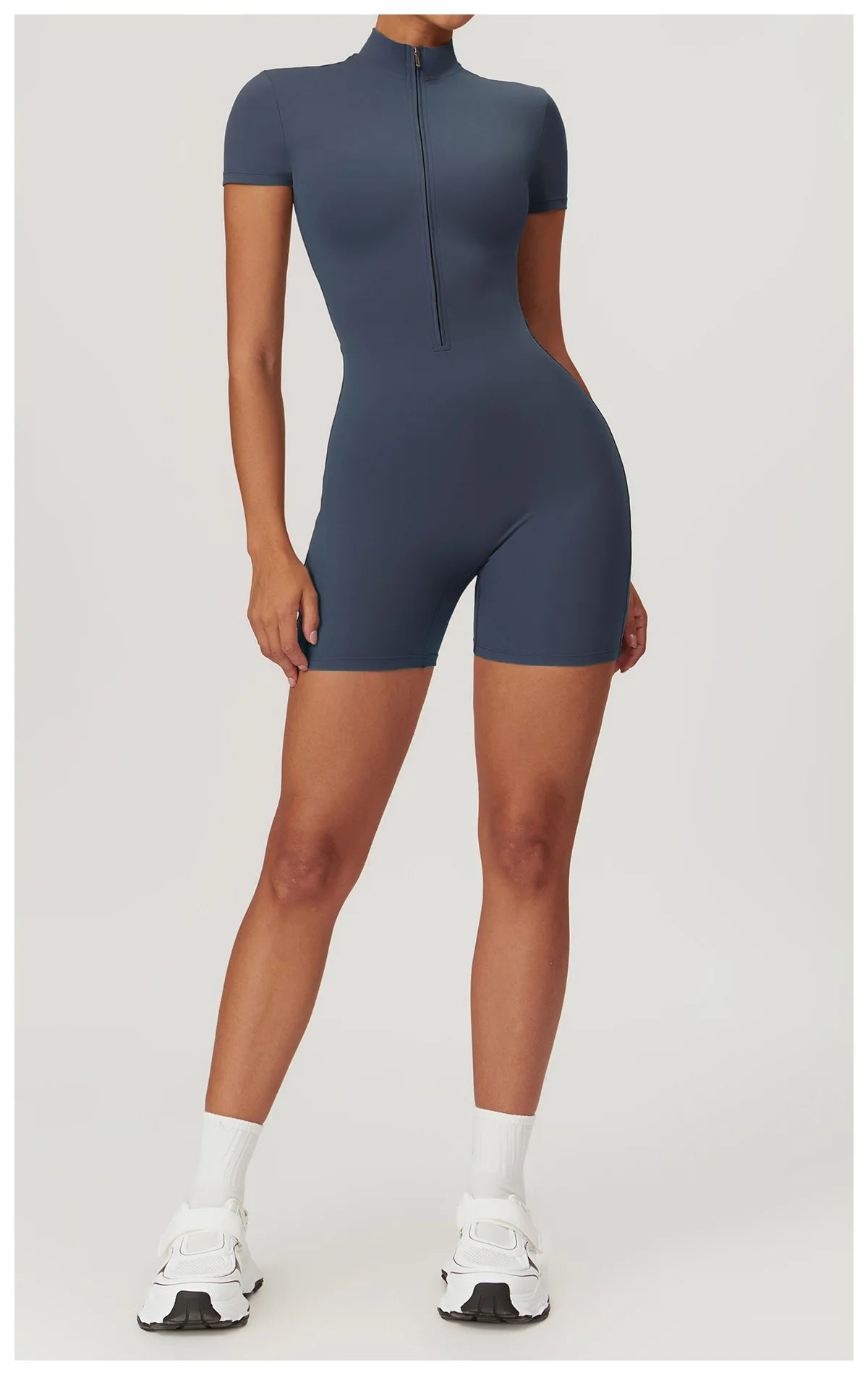 Person wearing a dark blue bodysuit on a light gray background
