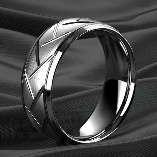 Silver ring with geometric design on a black fabric background