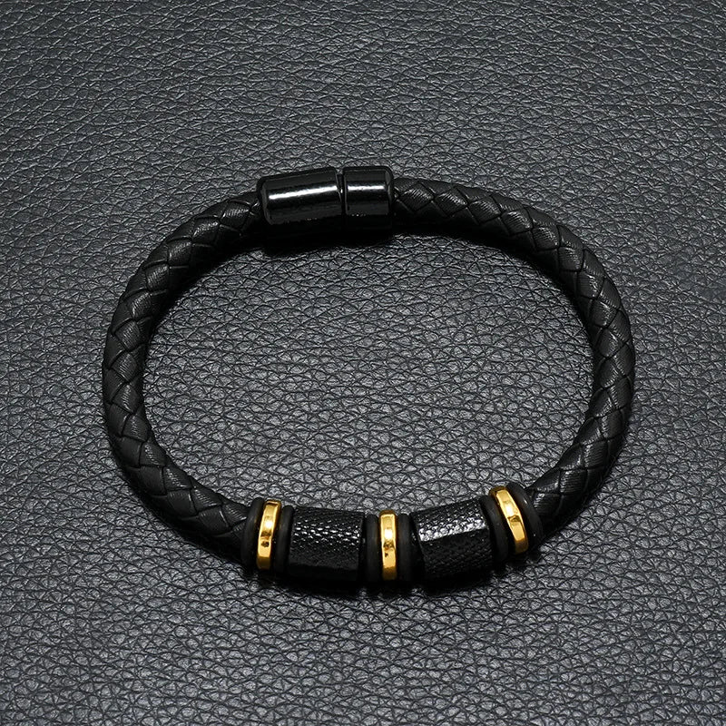 Black braided leather bracelet with gold accents on a textured black background