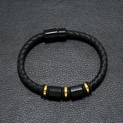 Black braided leather bracelet with gold accents on a textured black background