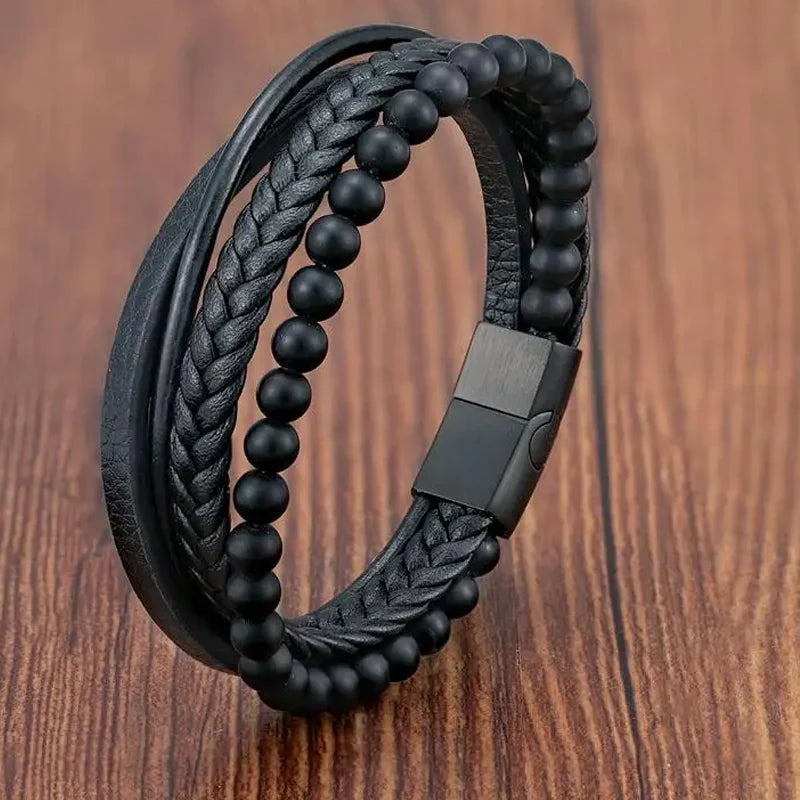 Black braided leather and beaded bracelet on a wooden surface