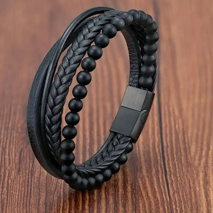 Black braided leather and beaded bracelet on a wooden surface