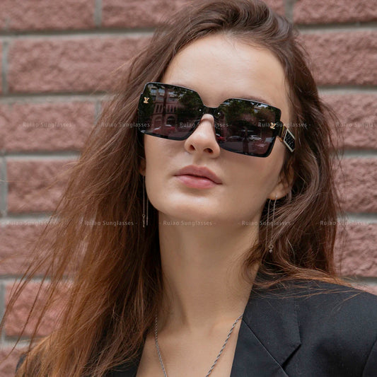 Woman wearing sunglasses with a brick wall background