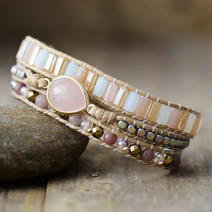 Beaded bracelet with pink stone on a stone surface