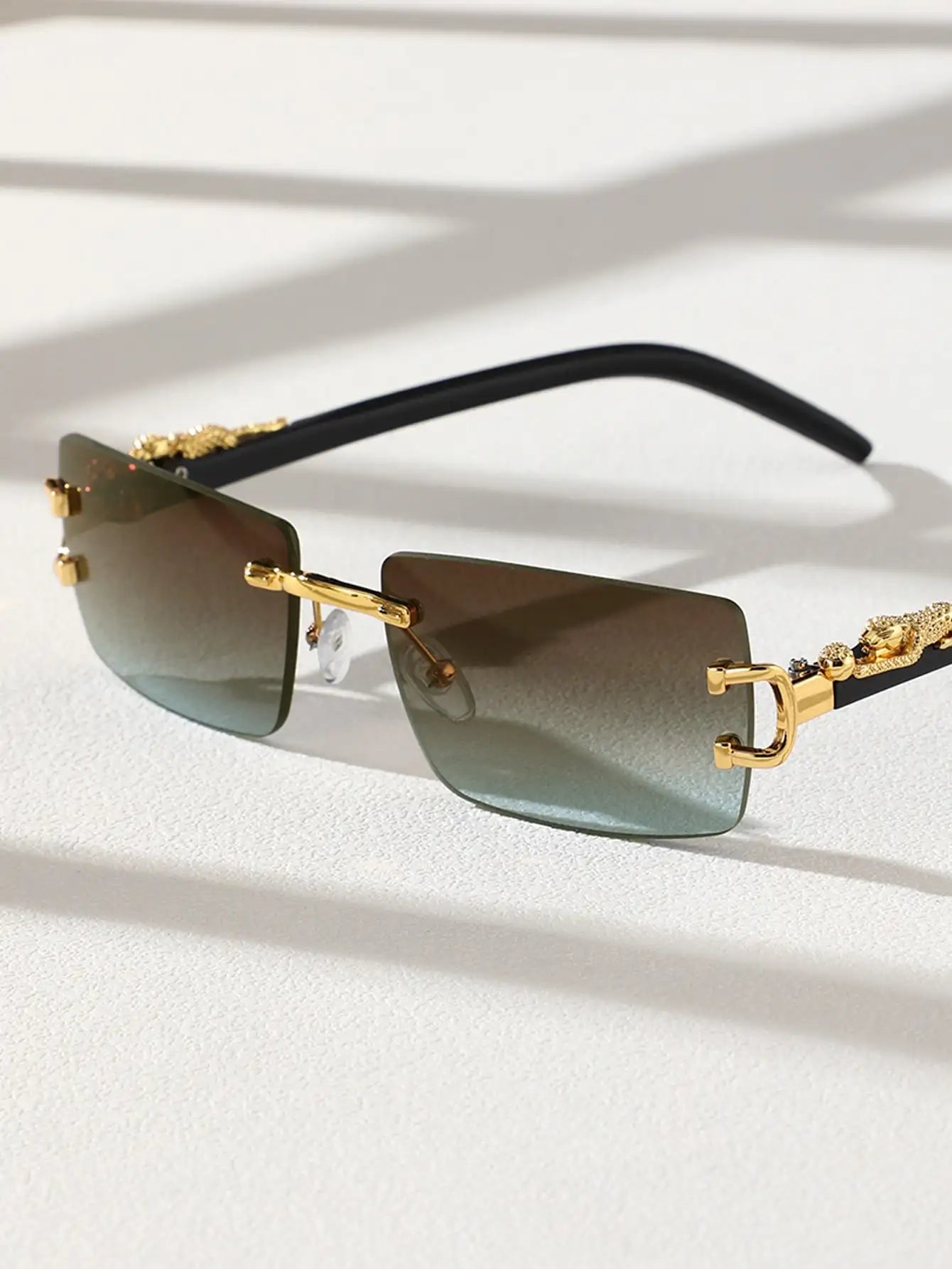 Gold-framed sunglasses with gradient lenses on a light background