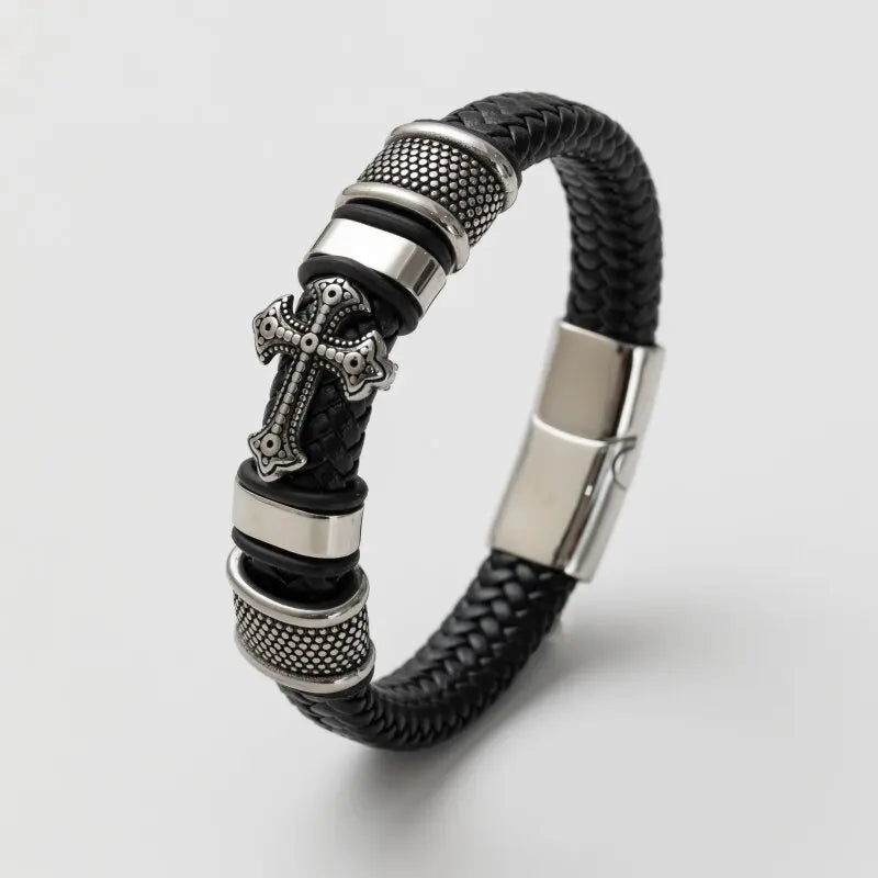 Black braided leather bracelet with silver cross charm and clasp on a light gray background